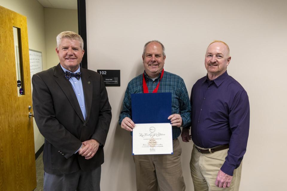 President John M. Berry, PhD; Chris Doll; Provost Gregory Ferenchak, EdD Chris Doll holds his League Excellence Award certificate while standing between COTC Provost Gregory Ferenchak and COTC President John Berry.