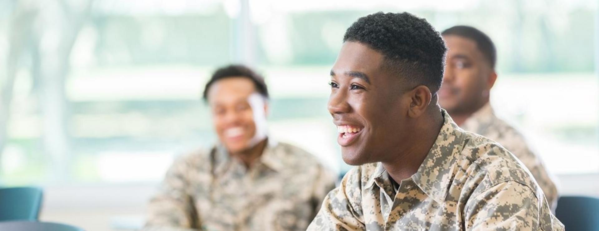 Students in army fatigues sit in a classroom.