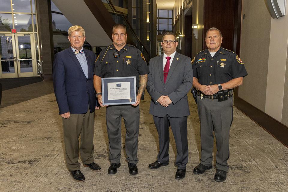 Deputy Tyler McMillen holding his award plaque stands with COTC President John M. Berry,  Peace Officer Basic Training Commander James Rease and Licking County Sheriff Randy Thorp