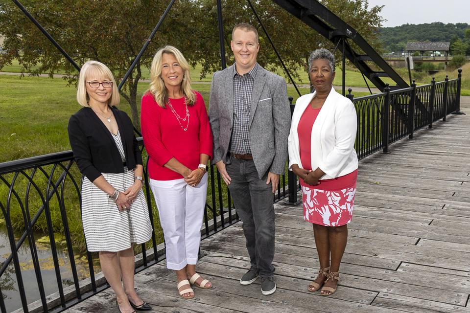 Kris Bowman, Faith Phillips, Chad Weirick and Vorley Taylor stand on a bridge near campus.