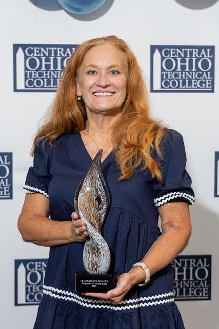 Jackie Parrill holds her Legends of Loyalty award trophy.