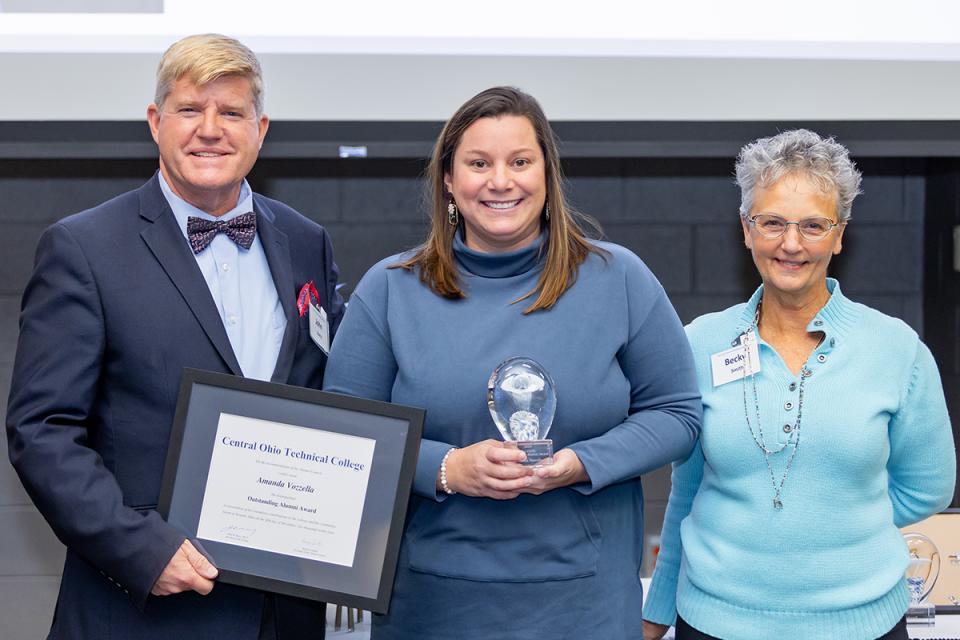 Amanda Vozzella stands with COTC President John Berry and COTC Alumni Council President Becky Smith after receiving the Outstanding Alumni Award.