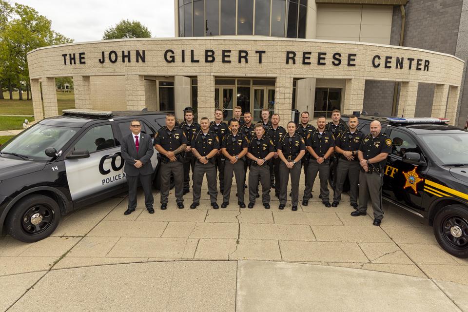 COTC cadets stand in a line between the Licking County Sheriff's and COTC's police academy  vehicles in front of the John Gilbert Reese Center on the day of their graduation. 