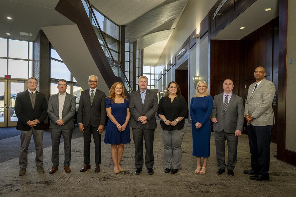 The members of the President's Cabinet stand in a line in the Reese Center.