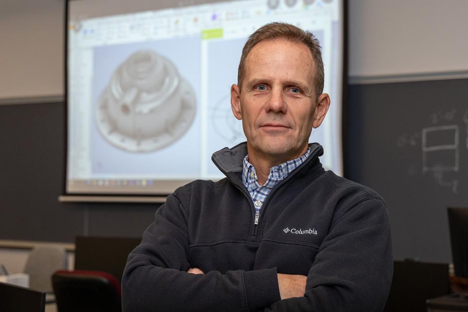 Headshot of Tom Comisford in a COTC classroom.