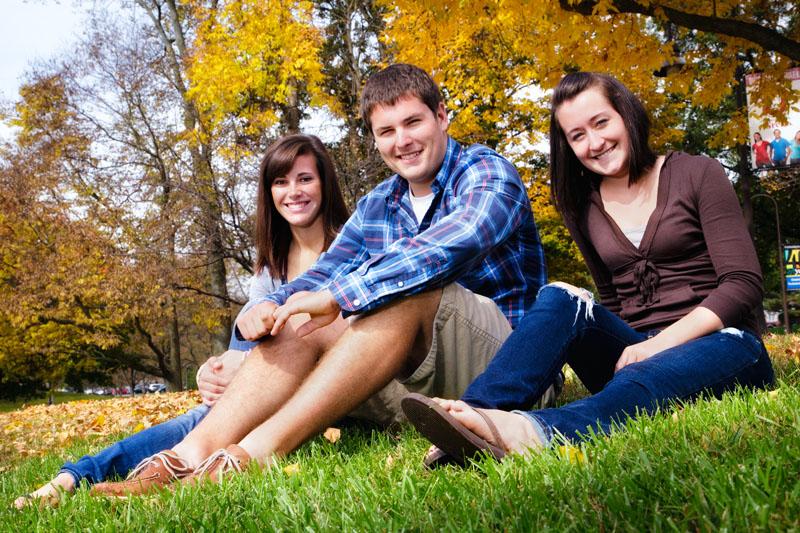 3 students sitting in grass