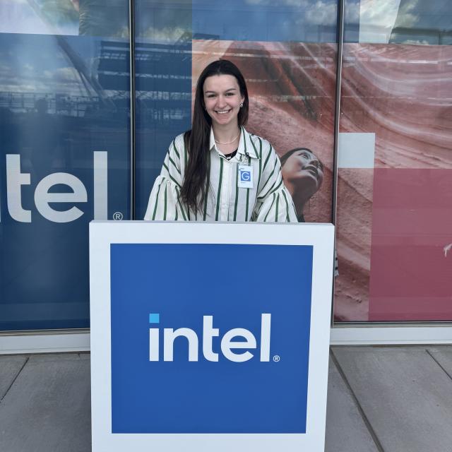 Alexis McPeck stands behind a podium with the Intel logo at their semiconductor factory, or fab, in Phoenix, Arizona.