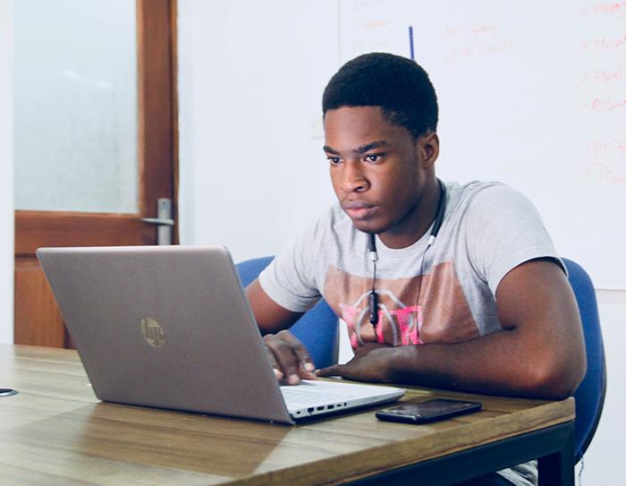 Young man sitting and looking at laptop