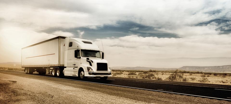 A semi-trailer drives on a road.