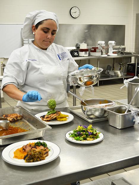 Chef adding finishing touches to dishes