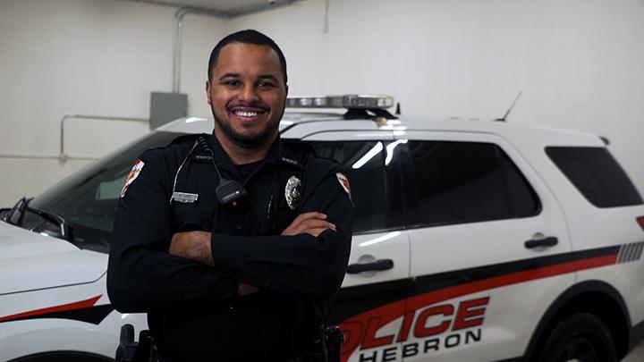 DeLane King standing in front of police cruiser. 