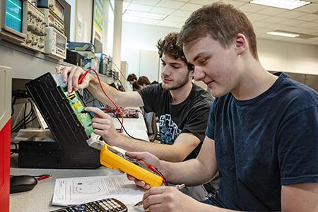 Two students work on an electrical board during class at COTC.