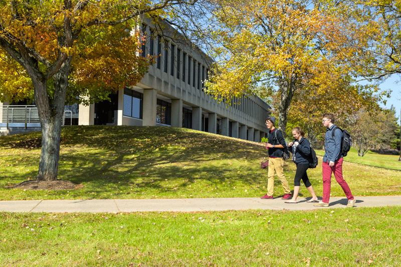 Three students walking across campus