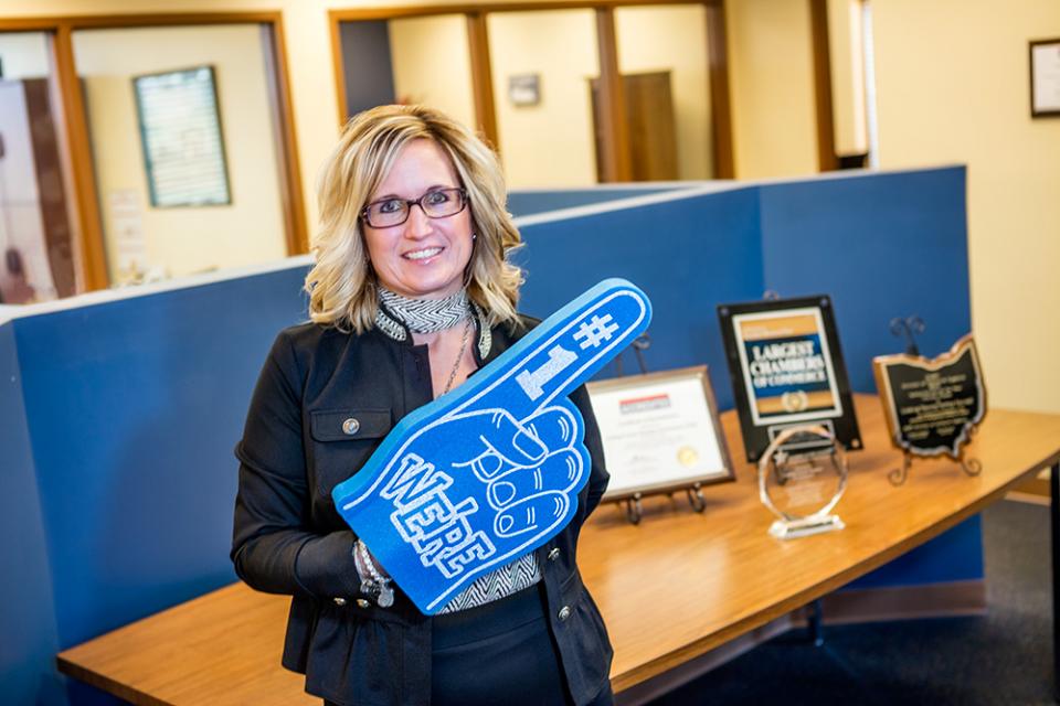 Jennifer McDonald wearing a #1 foam finger in her office.